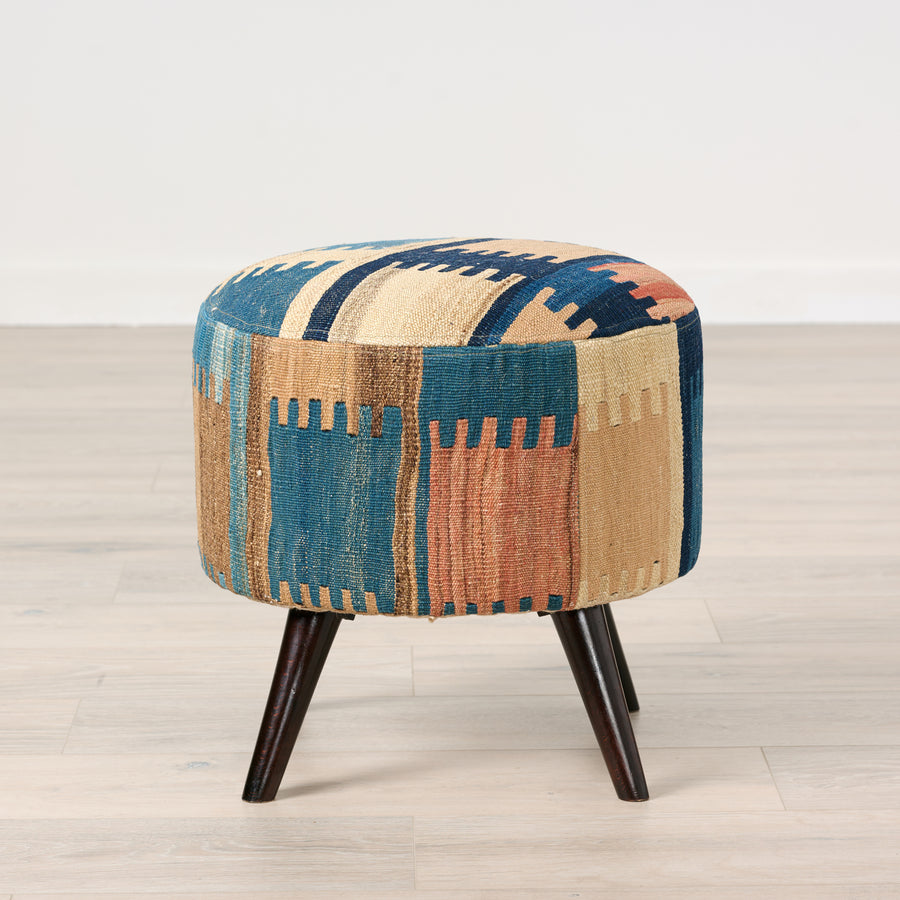 Multicolored patterned ottoman on a wooden floor