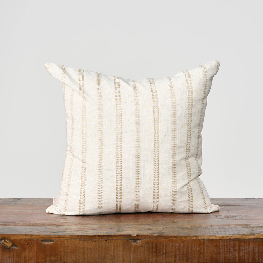 Striped pillow on a wooden surface with a light gray background