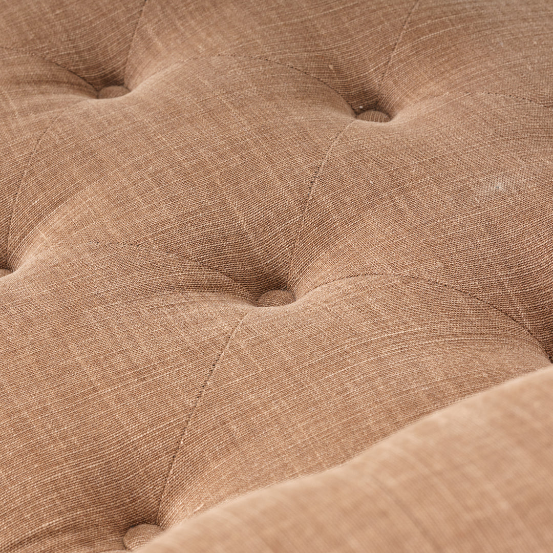 Close-up of a brown textured fabric surface with tufted design