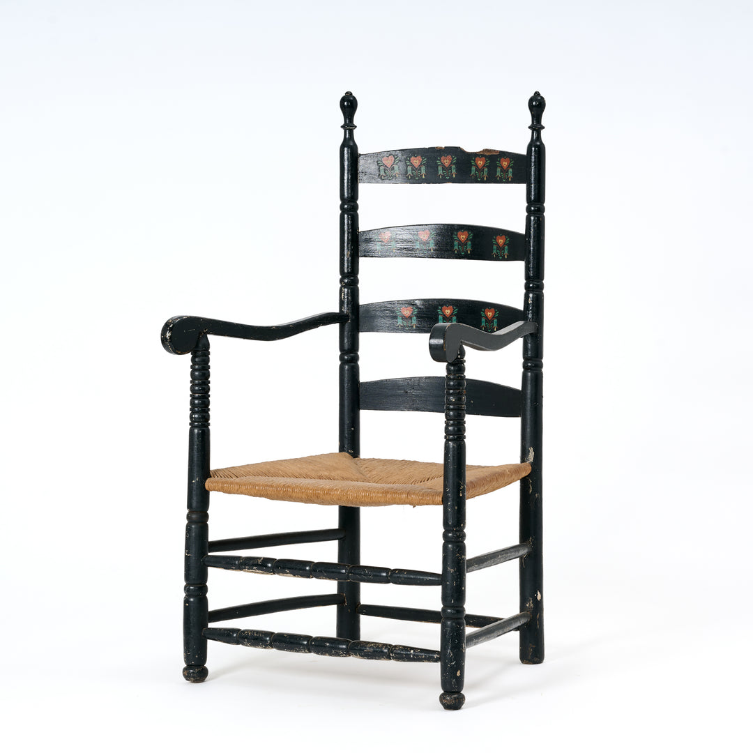 Black wooden chair with a woven seat on a white background