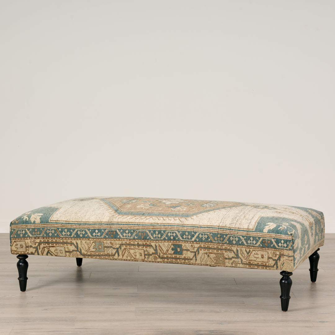 Decorative bench with patterned fabric on a wooden floor.