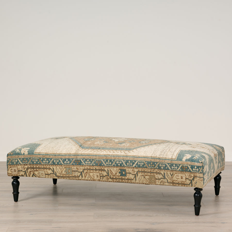 Decorative bench with patterned fabric on a wooden floor.