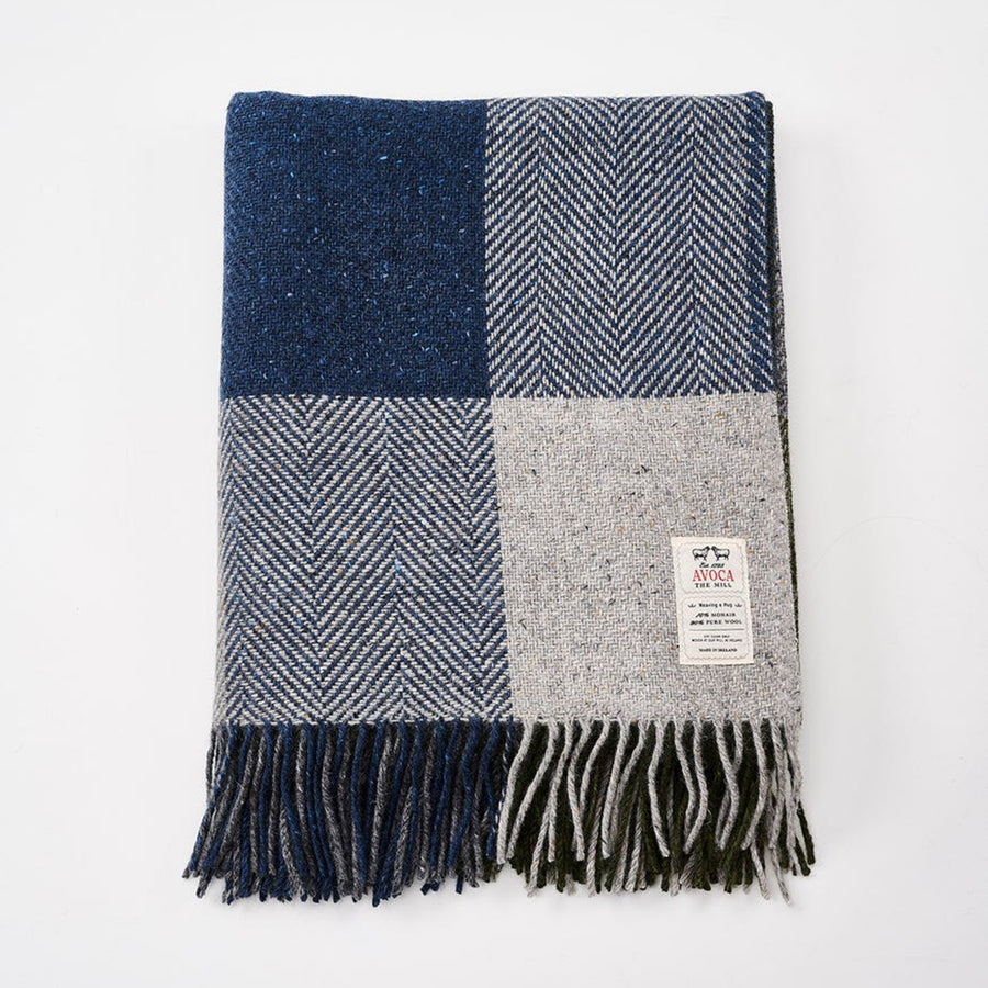 Plaid blanket with blue, gray, and white pattern on a white background