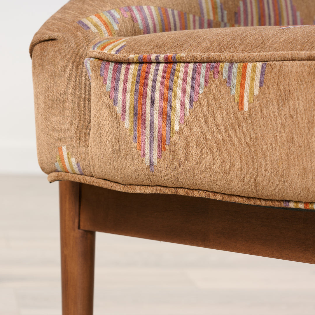 Brown upholstered chair with colorful striped pattern on a light background