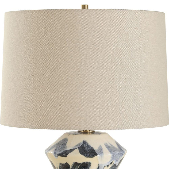 Table lamp with a beige fabric shade and a decorative ceramic base on a white background